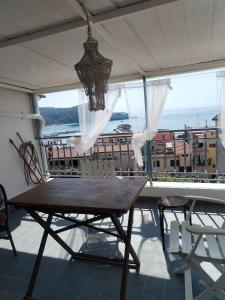 a balcony with a table and chairs and a chandelier at Casa vacanze Camera con vista in Marina di Camerota