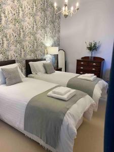 una camera da letto con due letti e un lampadario di 2 bedroom Townhouse within Grade C listed Ladysbridge House a Ladysbridge Station