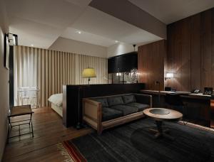 a living room with a couch and a bed at Hotel Proverbs Taipei in Taipei