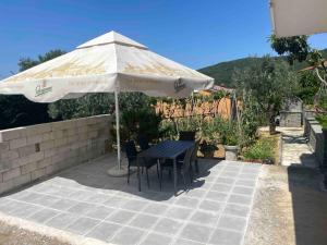 a table and chairs under an umbrella on a patio at Apartment Lucija - Dekani in Dekani