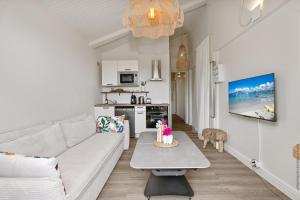 a living room with a white couch and a table at Le cocon Aimée in Fort-de-France