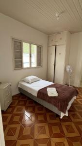 a bedroom with a large bed and a wooden floor at Hotel Colonial in Cajati