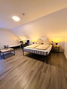 a bedroom with a large bed and two tables at emsRoom - Gästezimmer in Düne