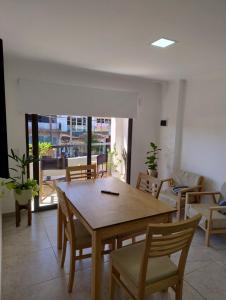 a dining room with a wooden table and chairs at Departamentos M&A 2 in Puerto Rico +2 photos