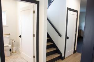 a hallway with a stairway leading to a bathroom with a toilet at 5 Minutes to the Falls-Luxury Home 3BR 2 Bath - USA Side in Niagara Falls +32 photos