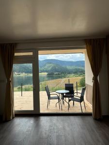 a dining room with a table and chairs and a large window at Complex Forest Sarnitsa in Sarnitsa