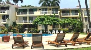 a group of lounge chairs in front of a building at NEW loft on the beach with direct access in Ixtapa
