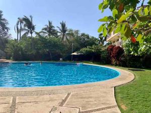 a large blue swimming pool with people in it at NEW loft on the beach with direct access in Ixtapa