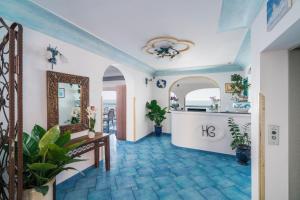 a hallway with a blue tile floor and a mirror at Hotel Il Gabbiano in Positano