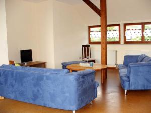 uma sala de estar com dois sofás azuis e uma mesa em Ferienwohnung Am Jakobsweg em Frielendorf