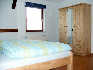 1 dormitorio con 1 cama y armario de madera en Ferienwohnung Am Jakobsweg, en Frielendorf