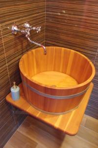 bañera de madera con grifo en el baño en Apartmánové byty so saunou a vírivkou, en Predajná