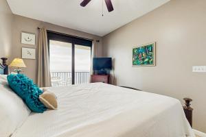 a bedroom with a large white bed with a window at Phoenix East in Orange Beach +19 photos
