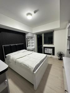 Un dormitorio con una cama grande y una chimenea. en JPC Skyline Condo in Azure pampanga, en Pampang