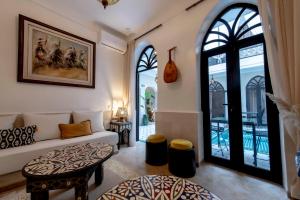 マラケシュにあるRiad Dar Yousraのソファとテーブルのあるリビングルーム