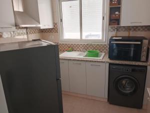 a kitchen with a black refrigerator and a microwave at Dar Chafia in Nabeul
