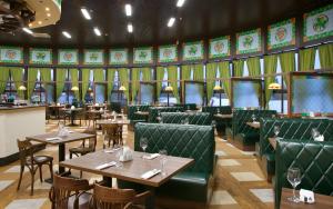 a dining room with tables and green booths at LESNOY Park Hotel in Solnechnogorsk