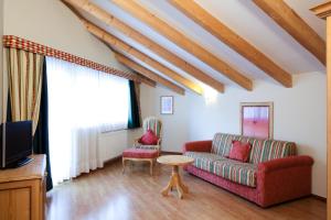 a living room with a red couch and a tv at Ciasa Anteriol in San Cassiano