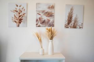 a table with vases on it with pictures on the wall at Da Vinci B&B in Florence