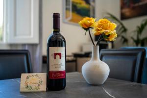 a bottle of wine sitting on a table next to a vase at Da Vinci B&B in Florence +19 photos