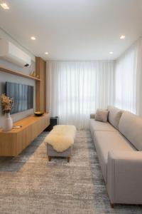 a living room with a couch and a tv at Villa di Tondo House II-Lindo apartamento in Bento Gonçalves