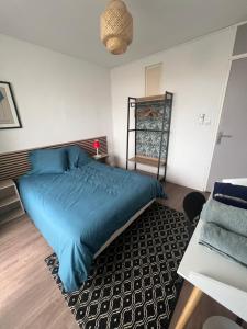 a bedroom with a blue bed and a rug at La Girelle vue mer proche plage in Toulon +17 photos