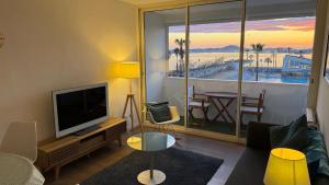 a living room with a television and a view of the ocean at La Girelle vue mer proche plage in Toulon