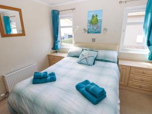 a bedroom with a bed with blue pillows on it at Heddwch in Stepaside