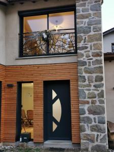 a house with a black door and a balcony at Les Ricochets in Coutenson +16 photos