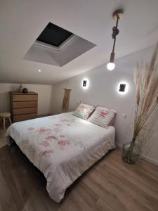 a bedroom with a bed with pink flowers on it at Les Ricochets in Coutenson