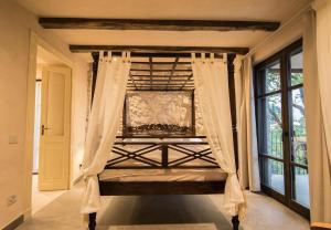 a bed with curtains in a room with a window at Casa Sopino 2 in Limone sul Garda