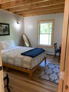 una camera da letto con un letto e una finestra di Farmhouse cottage close to Smugglers Notch a Cambridge