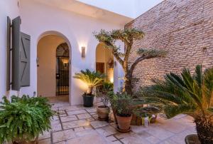 a courtyard with potted plants and a brick wall at Zarí Apartamentos in Córdoba