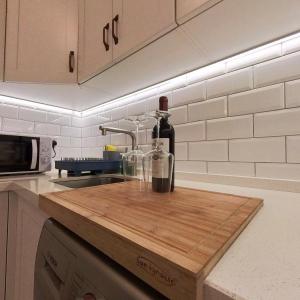 直布罗陀NEW Central Escape with Pool Access for Family of 4的厨房的切板上放一瓶葡萄酒