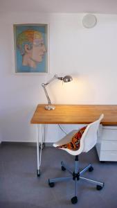 a desk with a lamp and a white chair at Charming Bright & Airy Loft Studio! in Ierápetra