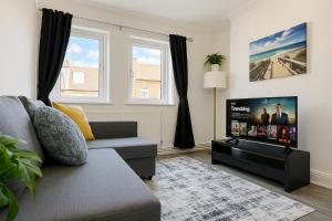 ロンドンにあるLuxury Flat by Tower Bridge, London - 2 Bedrooms, Free Parkingのソファと薄型テレビのあるリビングルーム