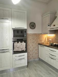 エンポリにあるVilla Iolandaの白いキャビネットと電子レンジを備えたキッチン