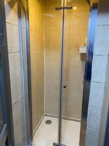 a shower with a glass door in a bathroom at Heathrow Platform Rooms in West Drayton +40 photos