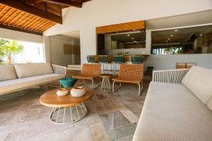 a living room with couches and a table and chairs at Baía Branca Beach Resort in Tamandaré