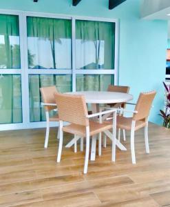 a white table and chairs in a room with windows at Baía Branca Beach Resort in Tamandaré