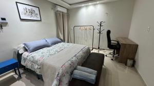 a bedroom with a bed and a chair in it at Studio a 5 km aeroporto Teresina in Teresina