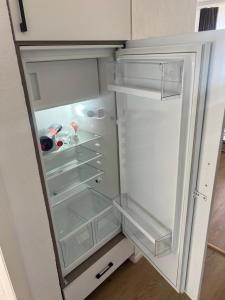 an empty refrigerator with its door open in a kitchen at Apartment CARMEN in Interlaken