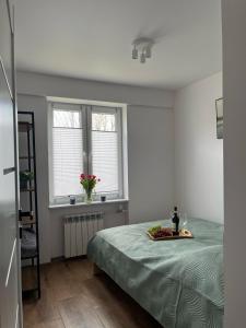 a bedroom with a bed and two windows at Apartament Dworska in Grodzisk Mazowiecki