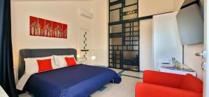 una camera da letto con un letto e una sedia rossa di Luxury Seaview Villa with Jacuzzi, Sauna & Gym in Amalfi Coast - Villa Dorotea a Minori