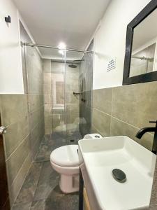 a bathroom with a toilet and a sink and a shower at HOTEL KALIFORNIAs in Bello