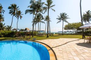 a swimming pool in a resort with palm trees at Baía Branca Beach Resort in Tamandaré