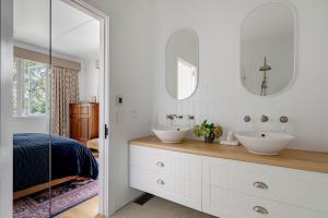 a white bathroom with two sinks and two mirrors at Blackheath Getaway in Blackheath