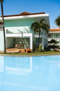 a large swimming pool in front of a house at Baía Branca Beach Resort in Tamandaré