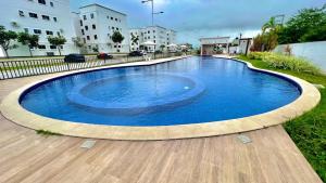 a large blue swimming pool on a wooden deck at Studio 06 in Caruaru