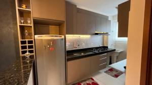 a kitchen with a stainless steel refrigerator and a stove at Studio 06 in Caruaru